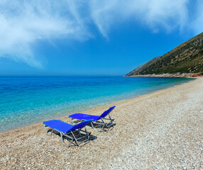 Summer morning beach with sunbeds, white sand and pebble (Albania).