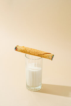 Waffle roll with condensed milk on a glass of milk