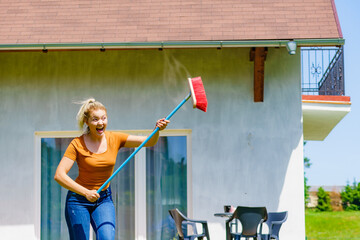 Woman with broom on backyard