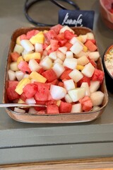 A fruit plate consisting of juicy red watermelon, melon, pineapple, all diced and lying in a beautiful bowl for buffet meals in a restaurant. Fruits on a plate. Close-up