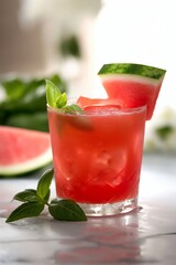 A glass of watermelon juice with a slice of watermelon on top