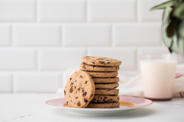 Cookies are spread out on a plate, a glass of fresh milk. Homemade cookies with chocolate chips.
