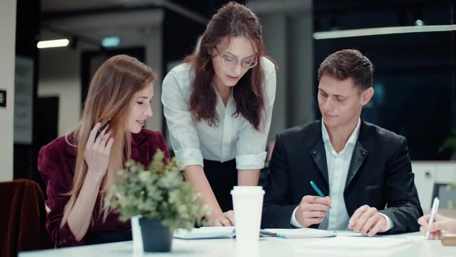 Confident young female leader manager communicate with business professional team people. Business people working together at office