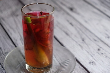 Wedang Jahe on a wooden table. A traditional herbs drink from Java Island, Indonesia, Its made of ginger, lemongrass, clove, some herbs, and rock sugar.