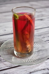 Wedang Jahe on a wooden table. A traditional herbs drink from Java Island, Indonesia, Its made of ginger, lemongrass, clove, some herbs, and rock sugar. Herbal drink for immune system booster. 