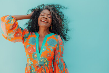 Senior woman smiling confidently, wearing a vibrant floral dress, capturing a moment of joy and positivity with her natural charm and elegance against a cheerful turquoise backdrop