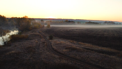 An empty plowed field in autumn at dawn