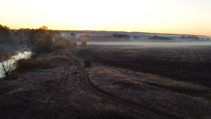 An empty plowed field in autumn at dawn