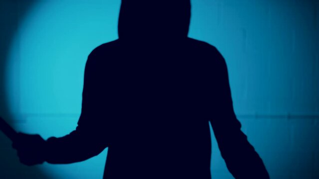 Silhouette of figure with a knife