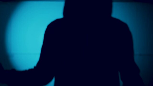 Silhouette of hooded figure with a knife