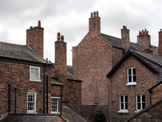 a group of old british brick houses with slate roofs and tall chimneys