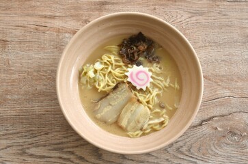 Tonkotsu ramen or Japanese yellow noodles topping slice barbecue pork in Miso soy sauce bone soup on bowl