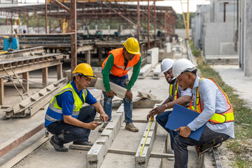 A team of constructors or engineers from different ethnicities work together in a precast factory...