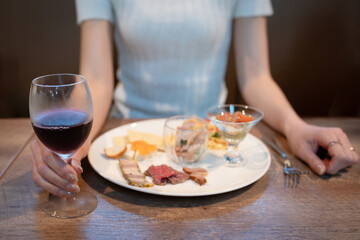 ワインを飲みながら食事をする女性
