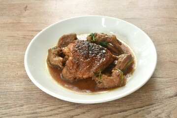 steamed chicken thigh and feet with garlic black pepper gravy sauce stew on plate