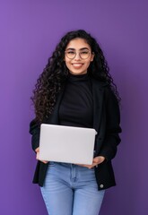 Happy young Hispanic woman, self-employed and ambitious, posing with a laptop against a vibrant violet background in a studio. 