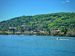 Fototapeta premium Scenic View of Stresa on Lake Maggiore with Lush Green Hills and Waterfront Buildings in Verbano-Cusio-Ossola, Piedmont, Italy