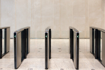 A row of turnstiles with a green arrow on the left side