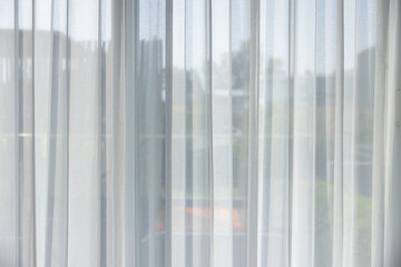 The white curtains are drawn, and the window is open, letting in a bright light