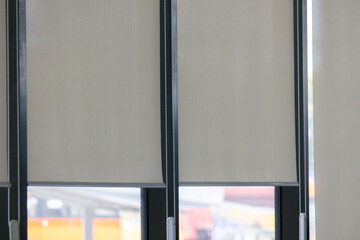 A window with white blinds and a view of a city