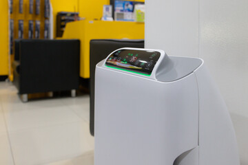 A white device with a green screen sits on a white stand