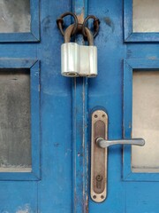 Old Locked Padlock Hanging On The Old Fashioned Blue Wooden Door.