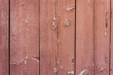 Background, texture of old brown wooden boards of the wall, doors with peeled paint. Close-up photo.
