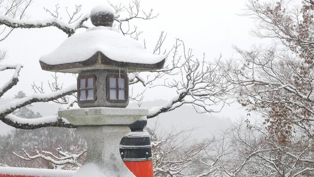 First snow falling on the rock lantern in shrine temples in Kurama mountain of kyoto, Japan. ancient Buddhism architecture in Kyoto Japan