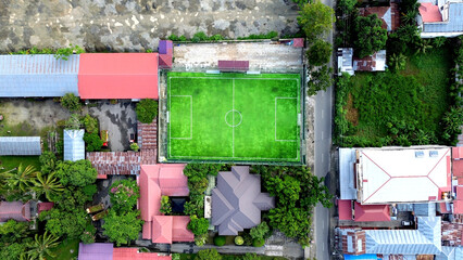 Top view of soccer field with green grass in the public park.