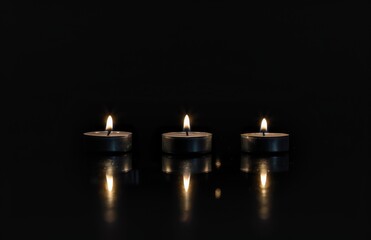 Minimalistic Tea Lights Providing Night Light in a Dark Room with a Black Background