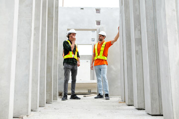 Engineer with concrete wall of prefabricated building.