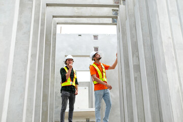 Engineer with concrete wall of prefabricated building.