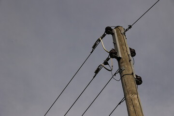 A tall power pole with wires running up it