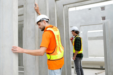 Engineer with concrete wall of prefabricated building.