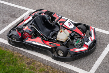Top view of a red black go-kart on the side of a track