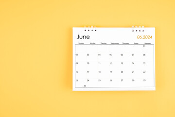 June 2024 desk calendar on yellow color background, position with copy space.