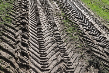 The dirt road is full of tire tracks