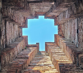 The brick polygon hole of ancient temple with blue sky  background at Nakhon luang castle, Phra...