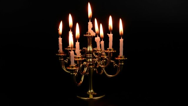 Candelabra with burning candles isolated on black background.