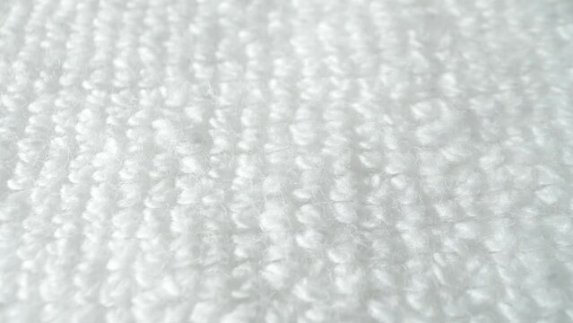 A captivating close-up reveals a pristine white fabric, its fibers soft and fluffy, boasting a subtle sheen. Dense loops of yarn form a plush texture, inviting touch and admiration.

