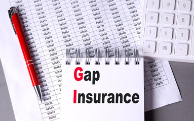 GAP INSURANCE text on notebook with chart , pen and calculator