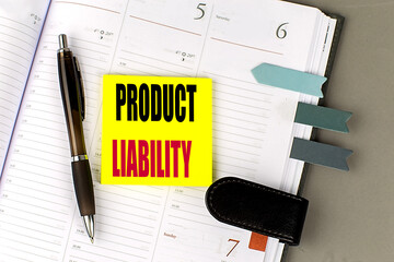 PRODUCT LIABILITY text sticky on dairy on gray background
