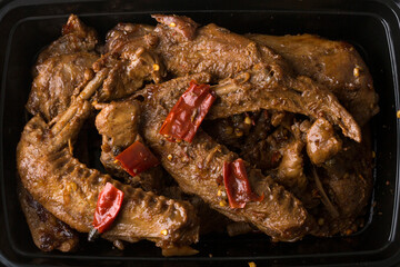 Chinese take out food spicy duck wings in a container
