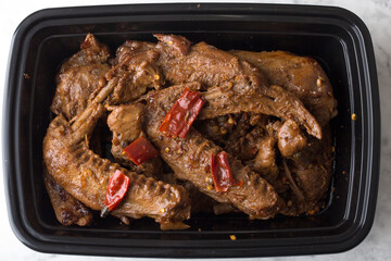 Chinese take out food spicy duck wings in a container