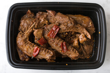 Chinese take out food spicy duck wings in a container