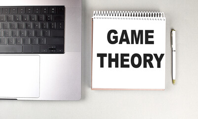 GAME THEORY text on notebook with laptop and pen