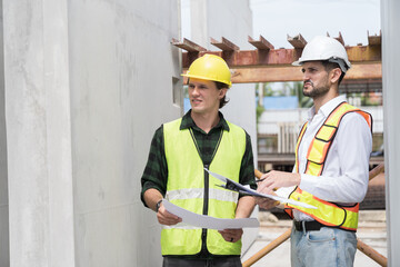 Team of male engineer construction working and inspecting structure of building at construction site. Two male construction builder working at construction site
