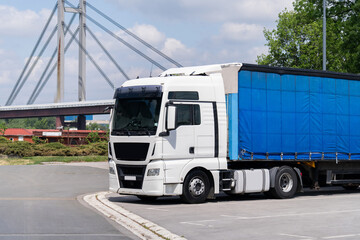 Parked white semi-truck with blue trailer.