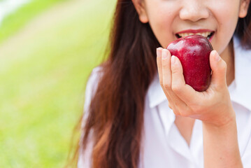 Young asian woman eating red Apple Healthy. Girl workout holding organic apple fruit healthy lifestyle. Wellness Asian women eat red apple smile face look at camera. Beauty health care lifestyle