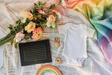 Transport yourself to a dreamy announcement setting: an aerial view captures a square black letter board nestled on a soft muslin blanket